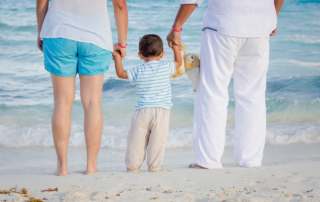 casal com filho pequeno na praia mostrando a eficacia da reversão de vasectomia