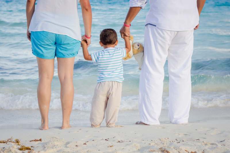 casal com filho pequeno na praia mostrando a eficacia da reversão de vasectomia